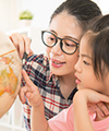 Mom teaching child to use the globe