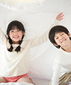 Siblings playing on bed