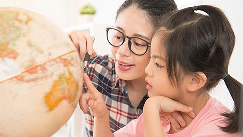 Mom teaching child to use the globe